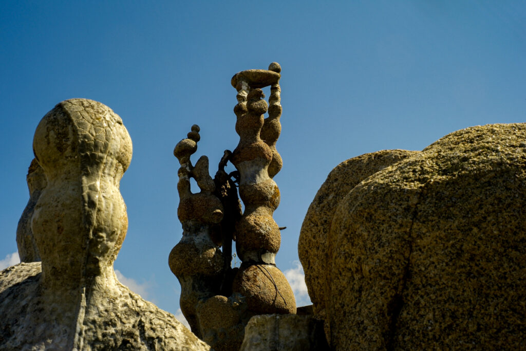 Abstract, organic stone sculptures created by Manfred Gnädinger under a clear blue sky in Camelle.