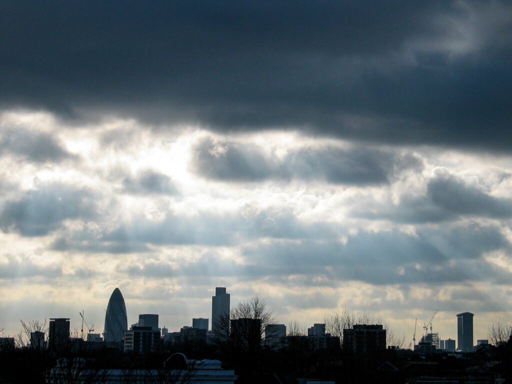 City of London skyline viewed from Hackney on Saturday 17 January 2004 at 14:21, with The Gherkin, Tower 42, and One Canada Square under expansive stratocumulus and altostratus cloud layers.