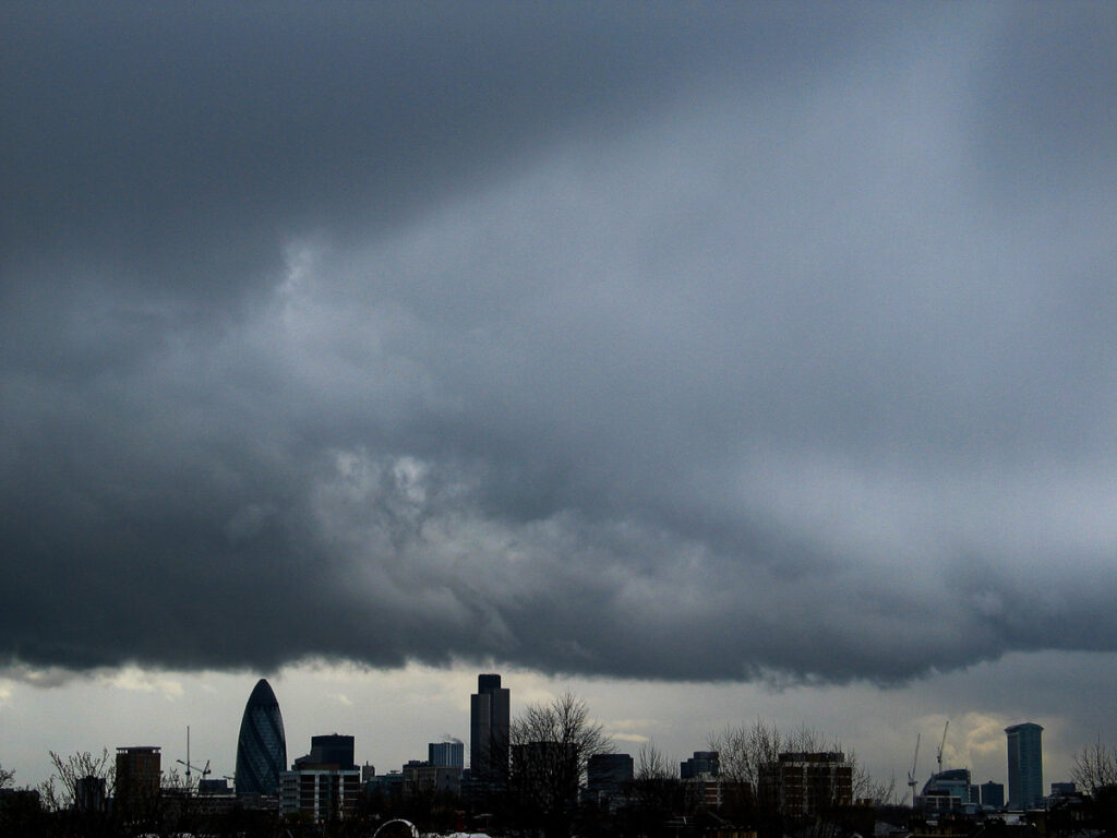 City of London skyline seen from Hackney on Friday 8 October 2004 at 15:53, featuring The Gherkin, Tower 42, and One Canada Square backed by menacing cumulonimbus and stratocumulus clouds.
