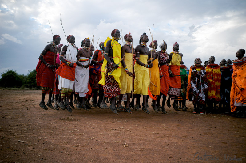Group of Samburu warriors dressed in colorful shukas and beadwork leap into the air together during a traditional dance in Kenya’s Rift Valley