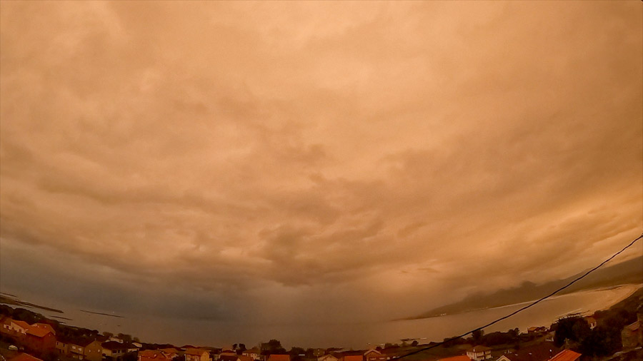Sunrise over Carnota Bay on the Costa da Morte with a uniform orange nimbostratus sky coloured by Saharan dust above Sofán village, Carnota beach, Monte Pindo, Caldebarcos and Cape Fisterra.